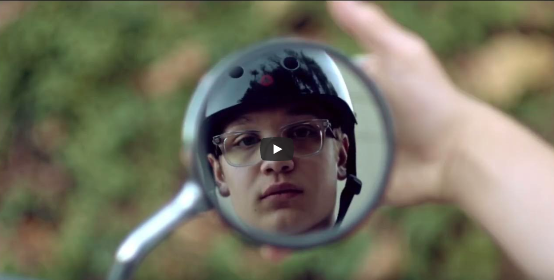 Born2Ride video covershot featuring a young man with a helmet on looking into a mirror.